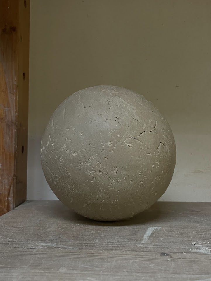 A finished sphere drying before its bisque firing.